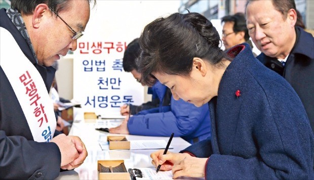 18일 판교역 광장의 '민생구하기 입법촉구 천만 서명운동’ 부스를 방문해 서명하는 박근혜 대통령. / 한경 DB