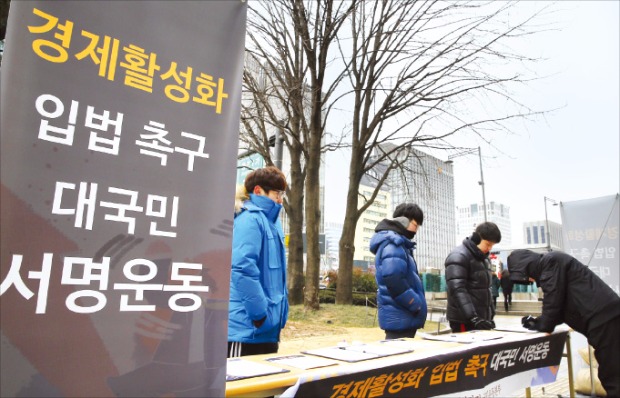 민생구하기 입법촉구 국민운동본부 회원들이 22일 서울 광화문역 앞에서 경제활성화 입법 촉구 대국민 서명을 받고 있다. 연합뉴스 
