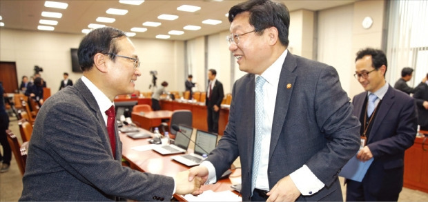 홍영표 국회 산업통상자원위원회 위원장 직무대행(왼쪽)과 주형환 산업통상자원부 장관이 25일 산업위 전체회의에서 기업활력제고를 위한 특별법(원샷법)이 통과된 뒤 악수하고 있다. 연합뉴스