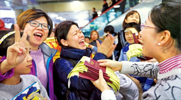 < “드디어 집으로” > 항공기 운항 중단으로 제주공항에 발이 묶였던 중국인 관광객들이 25일 중국행 항공권을 들고 활짝 웃고 있다. 연합뉴스