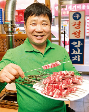 서울 자양동의 구경성양꼬치 가게 사장인 중국 동포 이학범 씨가 양꼬치를 들어보이며 웃고 있다. 그는 1997년 한국에 와 연매출 25억원의 사업체를 일궜다. 김병언 기자 misaeon@hankyung.com