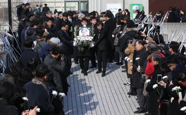 (서울=연합뉴스) 김주성 기자 = 18일 오전 서울 구로구 성공회대 대학성당에서 엄수된 고(故) 신영복 성공회대 석좌교수의 영결식에서 헌화하며 애도하는 추모객들 사이로 운구행렬이 지나고 있다.