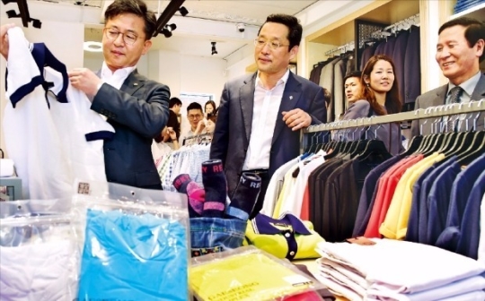 지난해 6월 홍용표 통일부 장관(왼쪽)이 서울 안국동에 마련된 개성공단상회를 방문, 옷을 살펴봤다. 개성공단상회는 개성공단 입주 기업 12곳이 협동조합 형태로 만든 직영상점이다. <한경DB>