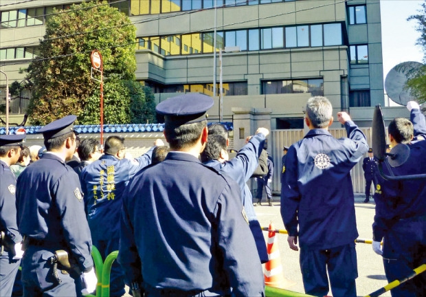 북한이 장거리 미사일을 발사한 지난 7일 일본 도쿄 지요다구에 있는 재일본조선인총연합회(조총련) 본부 앞에서 규탄 시위가 벌어지자 일본 경찰이 시위대 뒤에서 상황을 지켜보고 있다. 도쿄교도연합뉴스