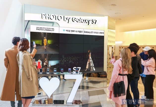 소비자들이 서울 동대문디자인플라자에 설치된 디지털 갤러리 앞에서 삼성 '갤럭시S7'으로 촬영한 2016 FW헤라서울패션위크를 감상하고 있다. / 사진=삼성전자