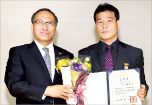 박형욱 여수시 팀장(오른쪽)이 17일 홍윤식 행정자치부 장관으로부터 대통령 표창을 받은 뒤 기념촬영하고 있다. 행자부 제공