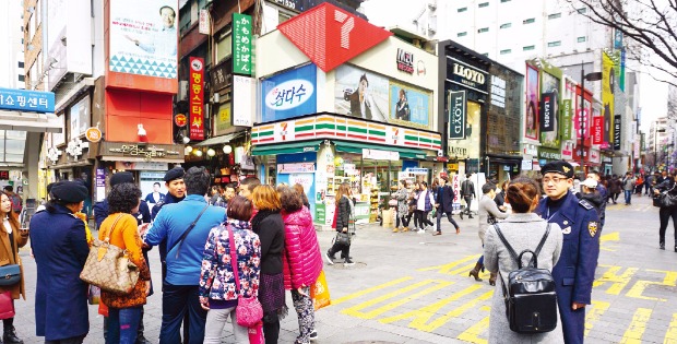 지난 17일 오후 서울 명동에서 제복을 입은 서울지방경찰청 관광경찰대원들이 외국인 단체관광 무자격 가이드 단속을 하고 있다. 관광경찰대의 제복은 ‘따뜻하고 친숙하며 엄정한 경찰’을 상징하는 짙은 청색의 더블재킷과 베레모로 구성돼 있다.  황정환 기자