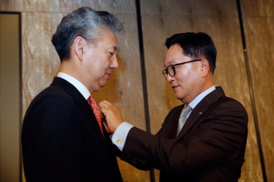 4일 업무보고에 앞서 박현주 회장이 홍성국 사장에게 미래에셋 뱃지를 직접 달아주고 있다.
