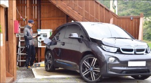 제주에서 게스트하우스를 운영하는 오성묵 씨가 집에 설치된 충전기를 이용해 전기차 BMW i3를 충전하고 있다.