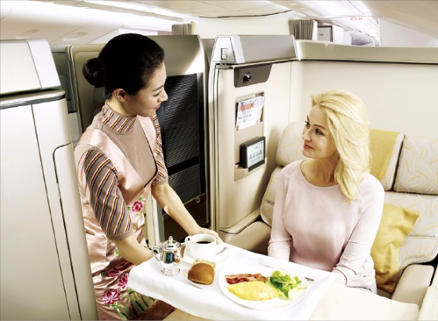 아시아나항공 승무원이 승객에게 기내식을 제공하며 다양한 기내 서비스를 소개하고 있다. 