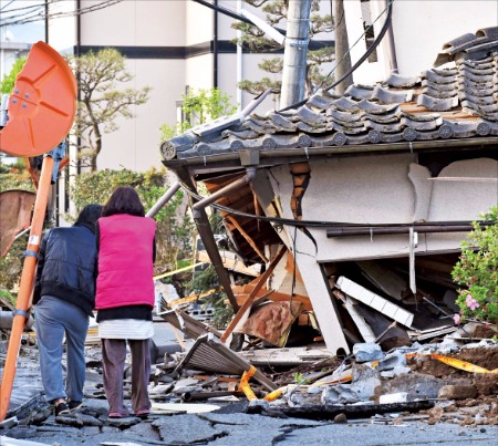 < 망연자실 > 일본 규슈 구마모토현에서 연쇄 지진이 발생한 지난 16일 남녀가 무너진 자신들의 집을 망연자실해 지켜보고 있다. 구마모토AFP연합뉴스