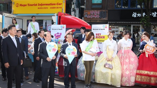 박홍섭 마포구청장(왼쪽에서 두번째) 등 관계자들이 지난달 29일 마포구 홍대 걷고싶은거리 특설무대에서 진행된 '외국인 관광객 환대주간' 기념행사에서 거리홍보에 나서는 모습. / 마포구청 제공. 