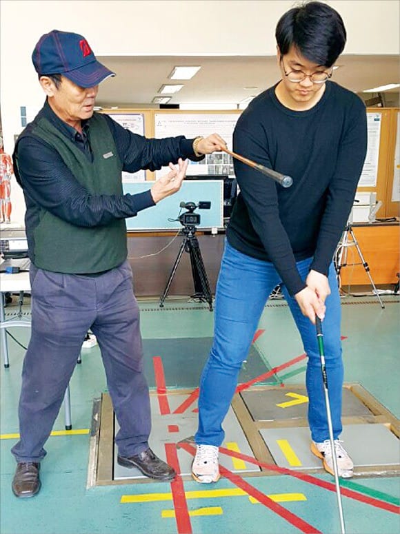 비거리를 제대로 내려면 오른쪽 어깨가 밀리지 말고 뒤로 바로 돌아야 한다. 강종철 프로가 골프 전공 학생의 어깨가 밀리지 않도록 잡아주고 있다.