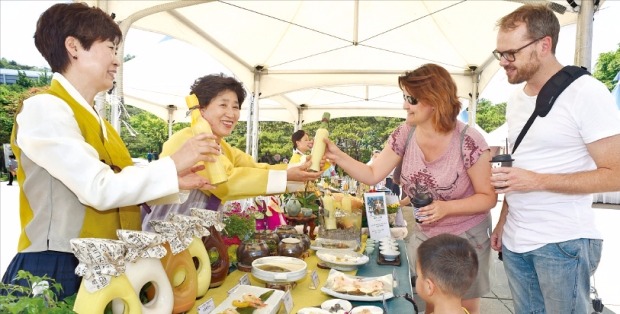 < 한옥마을서 전통주 행사 > ‘제9회 전통주와 전통음식의 만남 축제’가 19일 서울 퇴계로 남산골한옥마을에서 열렸다. 외국인 관광객들이 각종 전통주를 살펴보고 있다. 신경훈 기자 khhshin@hankyung.com