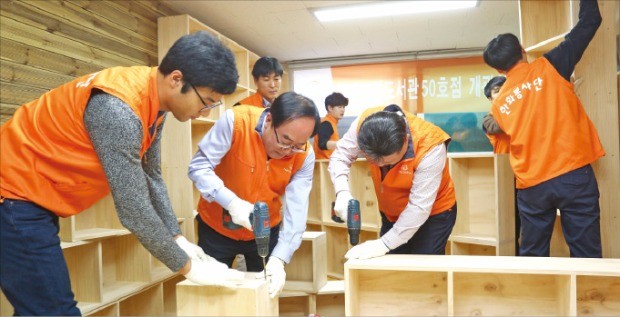 한화건설 임직원들이 지난해 말 서울 개봉동 에덴장애인 종합복지관에서 꿈에그린 도서관 50호점 설립 공사를 하고 있다. 한화건설 제공 