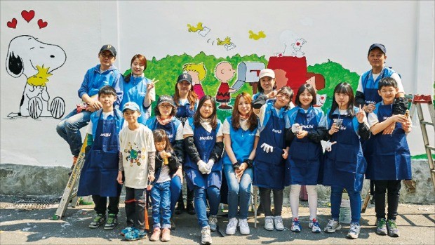 메트라이프생명 자원봉사단과 그 가족이 서울 상도동 일대에서 주거환경개선사업의 하나인 벽화그리기 자원봉사 활동을 마친 뒤 함께 사진을 찍고 있다. 