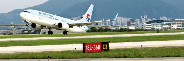 대한항공 항공기가 21일 김해국제공항 활주로를 떠나 날아오르고 있다. 정부는 이날 영남권 신공항 입지 선정 용역을 맡은 프랑스 파리공항공단엔지니어링(ADPi)의 연구 결과를 토대로 가덕도나 밀양에 신공항을 짓지 않고 기존 김해공항을 확장하기로 했다. 연합뉴스