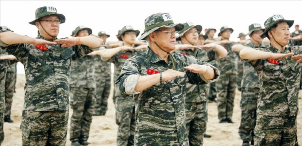 최신원 SK네트웍스 회장(가운데)과 팀장급 이상 임직원이 22일 경북 포항시 해병대 1사단에서 해상 기동훈련을 받기에 앞서 체력단련(PT) 체조를 하고 있다. SK네트웍스 제공