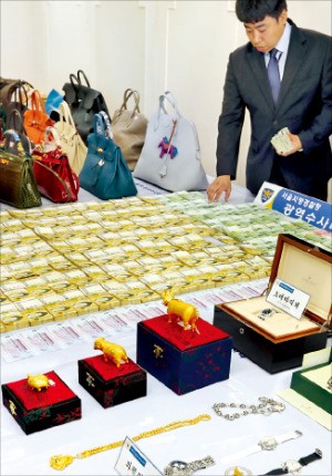 경찰이 11일 현금과 명품가방, 시계, 금송아지 등 압수품을 공개하고 있다. 연합뉴스