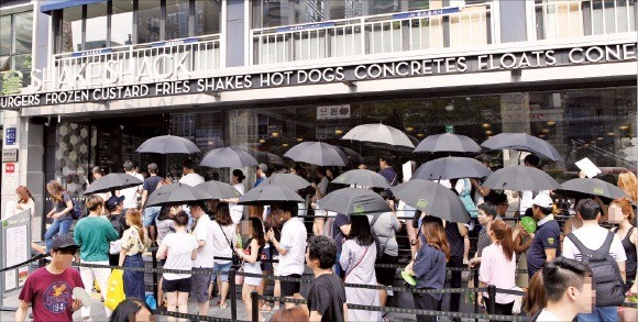 14일 쉑쉑버거 매장 앞에 양산을 든 고객들이 줄을 서 있다.