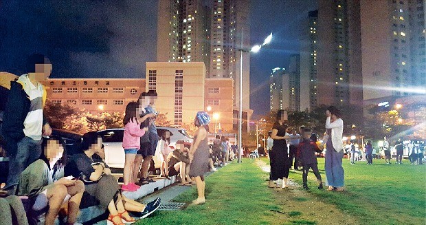 < 지진에 잠 못 이루는 밤 > 경북 경주에서 지진이 잇따라 발생한 12일 오후 부산 해운대 센텀시티 문화복합센터 앞 잔디밭에 인근 주민 수백명이 대피해 있다. 연합뉴스 