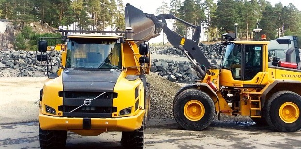무인 자율주행 기능을 갖춘 휠로더 L120(오른쪽)이 무인 자율주행 트럭 A25에 석재를 싣고 있다. 안대규 기자 