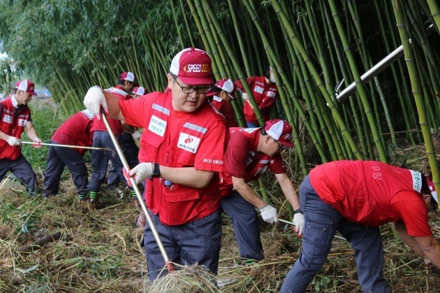 덕신하우징 임직원들이 태화강 대숲에서 자원봉사활동을 벌이고 있다.
