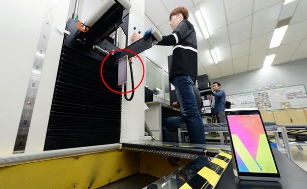 LG전자 연구원이 V20(붉은색 원안)를 바닥에 깔린 철판 위로 제품을 떨어트려 내구성을 테스트하고 있다. 