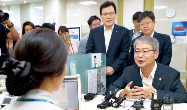 임종룡 금융위원장(오른쪽)은 지난 7월 서울 NH농협은행 광화문지점을 찾아 서민층을 위한 중금리대출 상품인 사잇돌 대출 판매 현황을 점검했다. 한경DB 