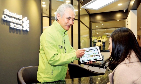 박종복 SC제일은행장(왼쪽)이 지난 1월 부산 신세계백화점 센텀시티점에 처음 문을 연 초소형 점포 ‘뱅크샵’에서 1호 고객에게 태블릿PC 기반의 플랫폼을 활용해 금융상담을 하고 있다. SC제일은행  제공 