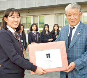 최신원 SK네트웍스 회장(오른쪽)이 지난 10일 경기 파주시 한민고를 방문해 장학금과 간식을 전달하고 있다. SK네트웍스 제공