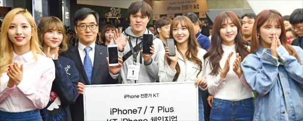 < “1호 가입 축하” > 애플 아이폰7이 출시된 21일 서울 광화문 KT 매장에서 1호 가입자로 선정된 유병문 씨(왼쪽 네 번째)가 김영호 KT 고객부문 영업본부장(세 번째)과 걸그룹 우주소녀의 축하를 받고 있다. 김영우 기자 youngwoo@hankyung.com