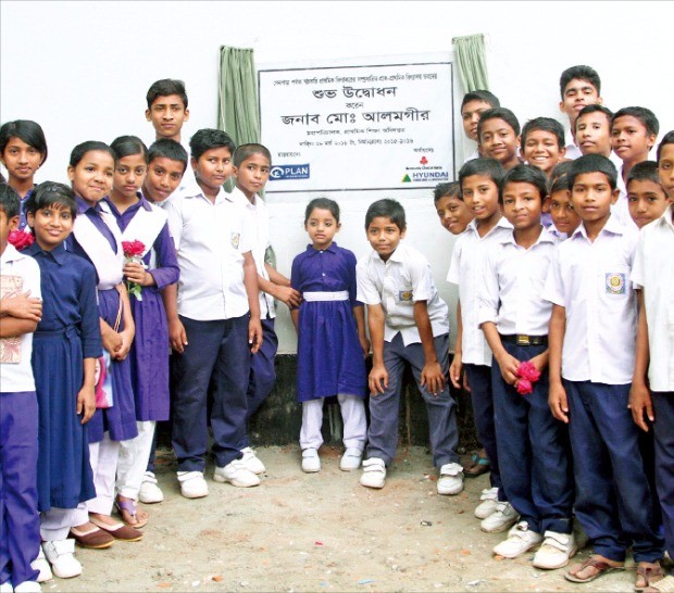 현대건설이 방글라데시에 증축한 공립 초등학교 학생들이 기념사진을 찍고 있다.  