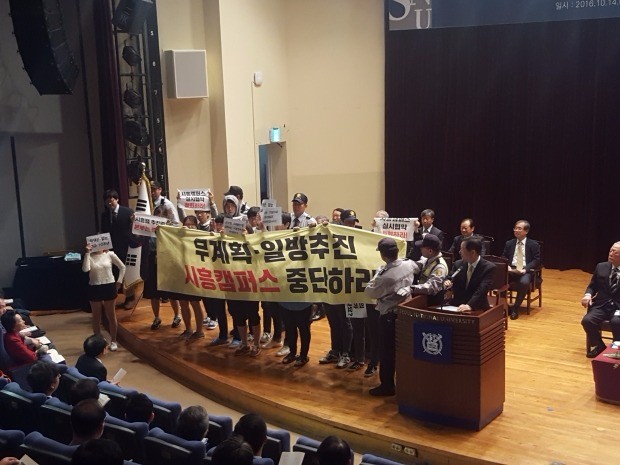 서울대 시흥캠퍼스 추진에 반대하는 학생들이 14일 교내에서 열린 ‘개교 70주년 기념식’ 도중 단상에 올라가 시위하고 있다.
