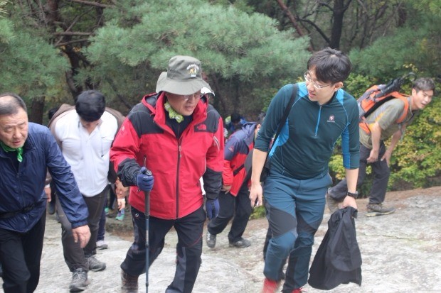 정우택 의원이 산에 오르며 기자(오른쪽)의 질문에 답하고 있다.