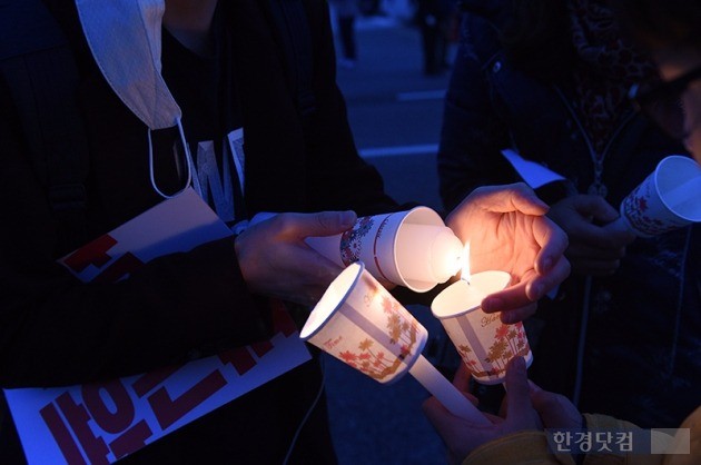 지난 12일 '최순실 국정 농단' 관련 촛불집회(민중총궐기)가 서울 도심 곳곳에서 열렸다. 광화문 광장에서 열린 집회에 참가한 시민들이 서로의 초에 불을 붙여주고 있다. / 최혁 기자 chokob@hankyung.com