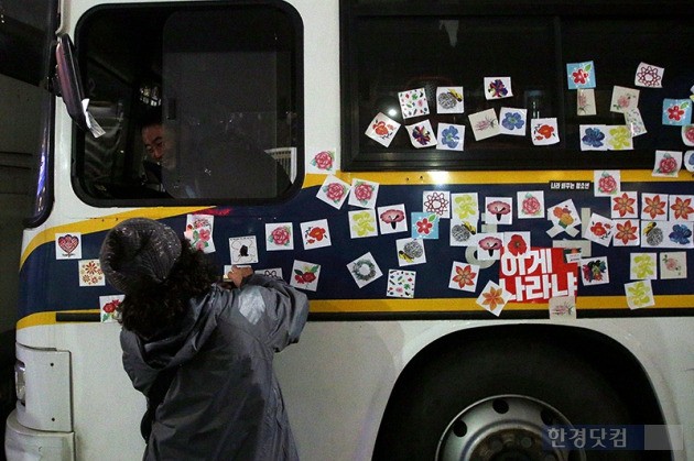 19일 오후 서울 광화문 광장에서 열린 박근혜 정부 퇴진을 요구하는 '4차 촛불집회'에서 한 시민이 경찰버스에 스티커를 붙이고 있다. / 최혁 한경닷컴 기자 chokob@hankyung.com