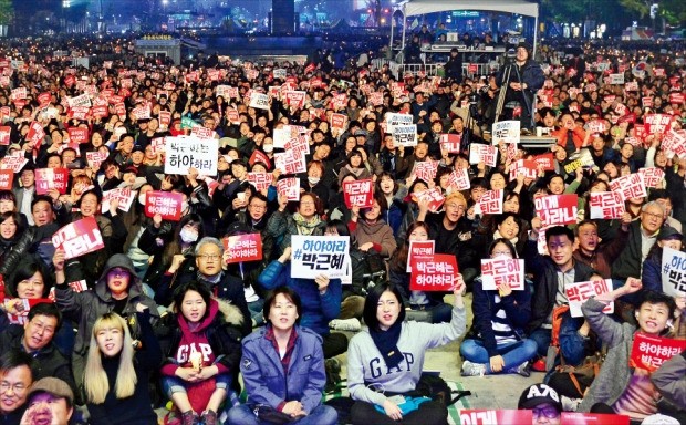서울 광화문광장에서 지난 5일 열린 촛불집회에 참가한 시민들이 박근혜 대통령의 퇴진을 요구하는 종이카드를 든 채 시위하고 있다. 강은구 기자 egkang@hankyung.com