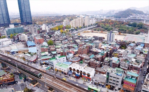 저층 노후주택이 밀집한 서울 뚝섬역사거리 인근 성수동1가 전경. 서울시는 이 일대 재개발과 리모델링 사업을 활성화하기 위해 땅의 종상향을  추진하고 건축물 높이제한을 완화하는 절차를 밟고 있다.  왼쪽 쌍둥이 고층 건물은 주상복합 갤러리아포레. 신경훈 기자 khshin@hankyung.com 