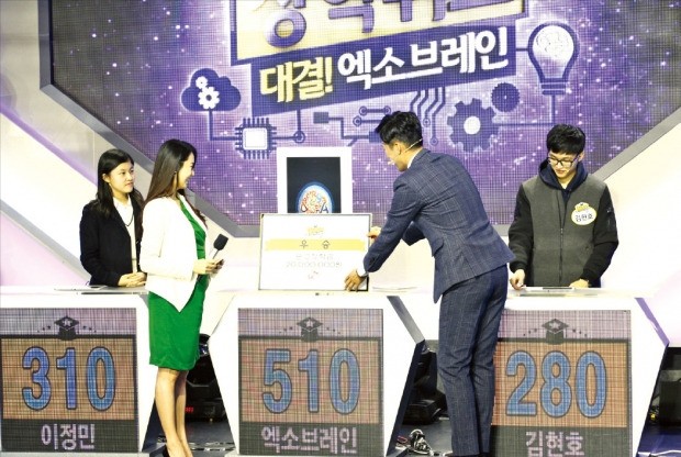지난 18일 대전에서 열린 EBS 장학퀴즈 프로그램에서 사회자가 우승을 차지한 한국형 인공지능 엑소브레인에 우승 상금을 전달하고 있다. ETRI 제공
