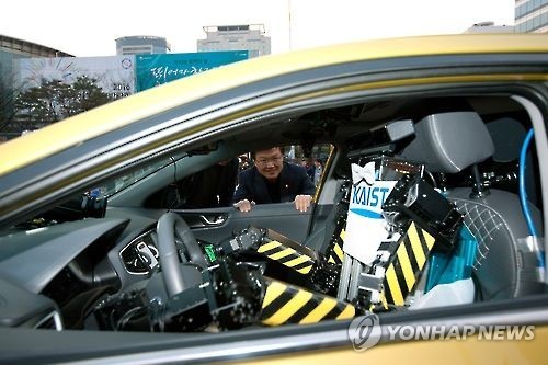 미래창조과학부와 산업통상자원부가 3일 오후 서울 강남구 영동대로에서 '2016 미래성장동력 챌린지 퍼레이드' 를 개최했다. 최양희 미래부 장관이 현대자동차의 소형전기차 '아이오닉'을 운전하는 로봇 드라이봇'을 보고 있다. 미래창조과학부 제공