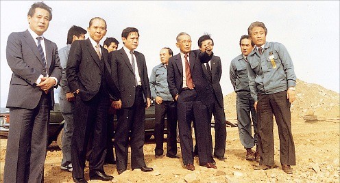 < 이날이 있었기에… > 1983년 경기 기흥 반도체공장 건설 현장을 찾은 이병철 삼성그룹 창업주(앞줄 왼쪽 네 번째)와 이건희 삼성 회장(세 번째). 한경DB