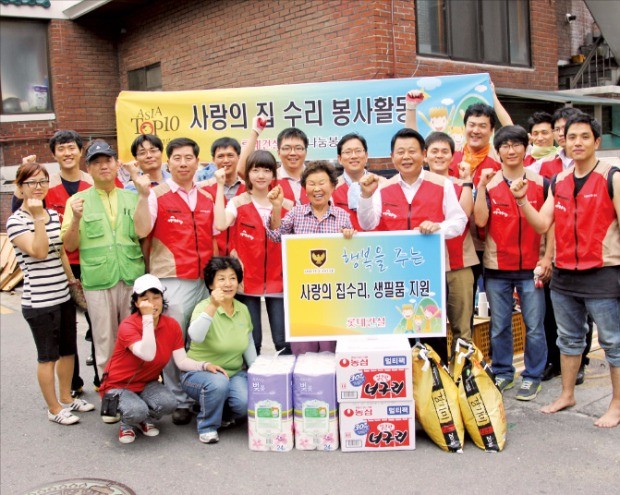 롯데건설 임직원들이 ‘사랑의 집수리’ 봉사활동을 하고 기념촬영하고 있다. 