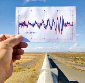 한 연구자가 고급레이저간섭계중력파관측소(LIGO)를 배경으로 2015년 9월14일 검출된 첫 중력파 파형을 그린 그래프를 들고 있다. 사이언스 제공