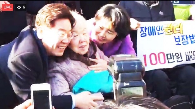23일 이재명 성남시장(오른쪽)이 어머니(가운데)와 함께 경기도 성남시 오리엔트 시계공장에서 대선 출마 선언을 하고 있다.  이 시장은 12살부터 어머니 손을 잡고 학교 대신 이 공장으로 출근한 바 있다. 사진=신세원 기자 