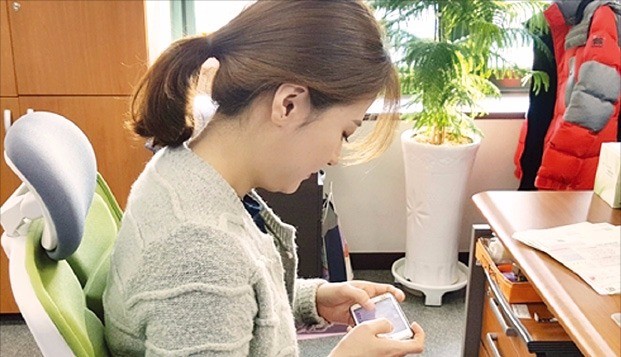 한 여성이 스마트폰으로 모바일 게임을 하고 있다. 자생한방병원 제공 