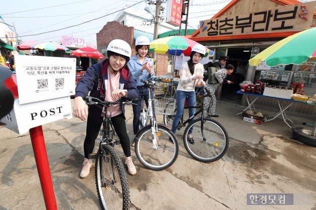 28일 인천 강화군 교동도 대룡시장을 찾은 자전거 여행객이 스마트워치로 전자스탬프를 받고 있다. / 사진=KT 제공
