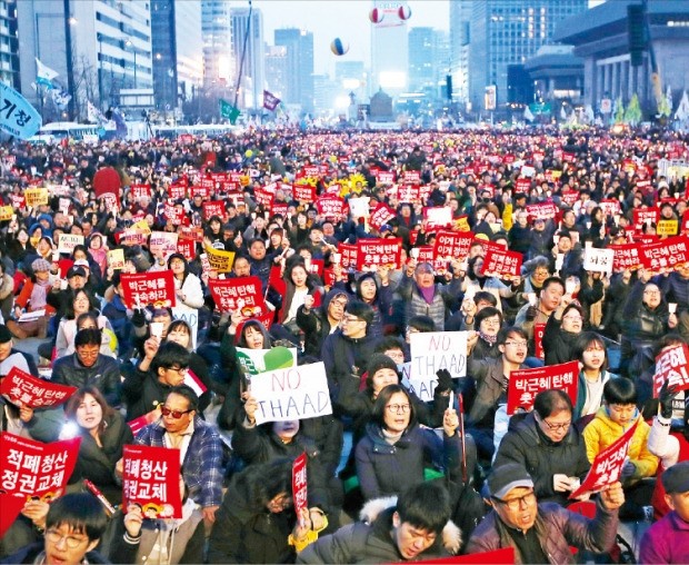 헌법재판소가 박근혜 대통령 파면을 결정한 다음날인 지난 11일 저녁 서울 광화문광장에 모인 시민들이 촛불과 피켓을 들고 탄핵을 환영하는 집회를 하고 있다. 연합뉴스