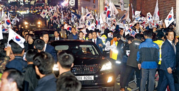 박근혜 전 대통령을 태운 차량이 지지자들에 둘러싸인 채 12일 저녁 서울 삼성동 박 전 대통령 자택 앞 골목길에 들어서고 있다. 신경훈 기자 khshin@hankyung.com