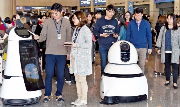 LG전자 연구원들이 인천국제공항 입국장에서 안내로봇(왼쪽)과 청소로봇을 테스트하고 있다. 허문찬 기자  sweat@hankyung.com